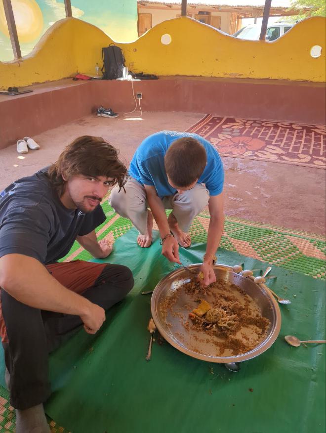 Roger and Jaume competing to see who can eat more Thiebou djen <em>rouge</em>